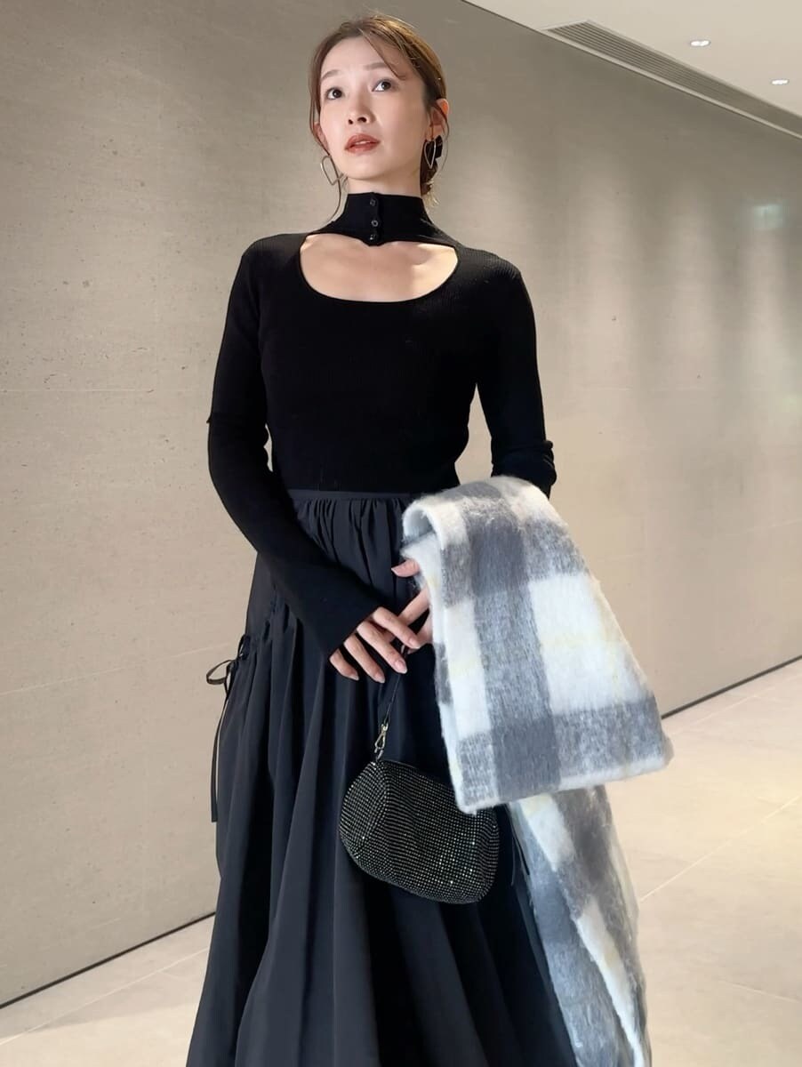 ブラック系のスカート、ブラック系のニット/セーター、グレー系のストール/ショールを着用したレディースの秋コーディネートの4枚目の写真