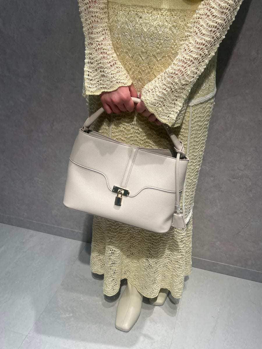 イエロー系のスカート、イエロー系のニット/セーター、ホワイト系のハンドバッグを着用したレディースの春コーディネートの5枚目の写真