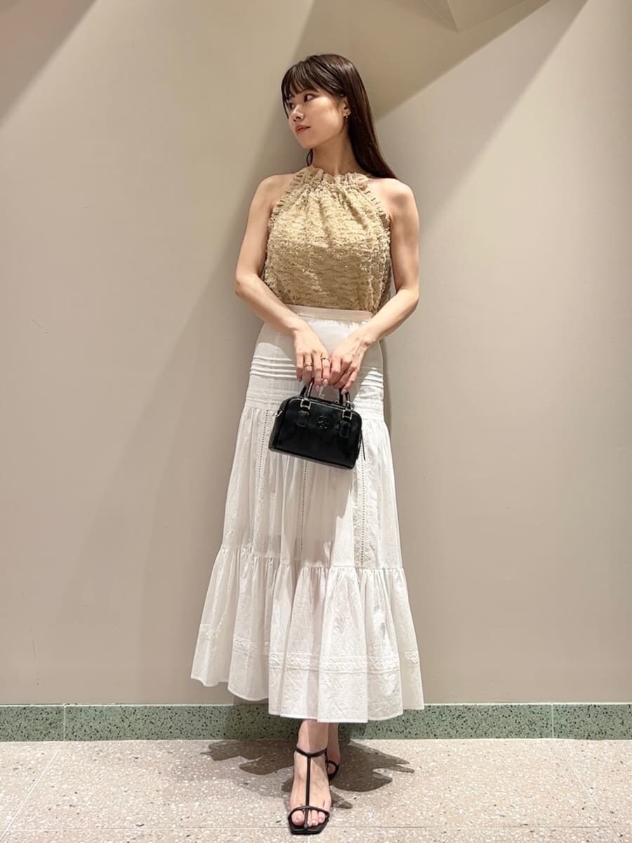 イエロー系のTシャツ/カットソー、ホワイト系のスカート、ブラック系のショルダーバッグを着用したレディースの夏コーディネートの3枚目の写真