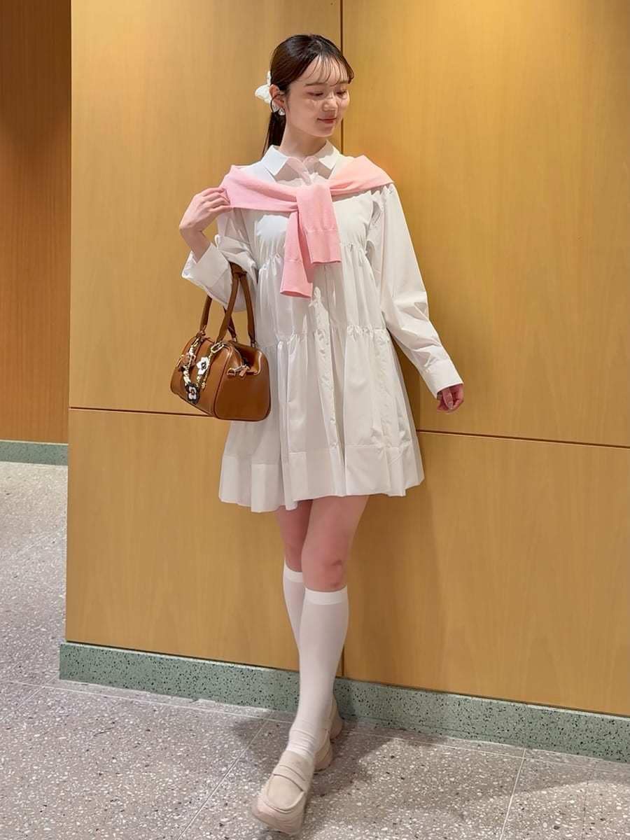 ホワイト系のワンピース、レッド系のカーディガン/ボレロ、イエロー系のボストンバッグを着用したレディースの春コーディネートの2枚目の写真