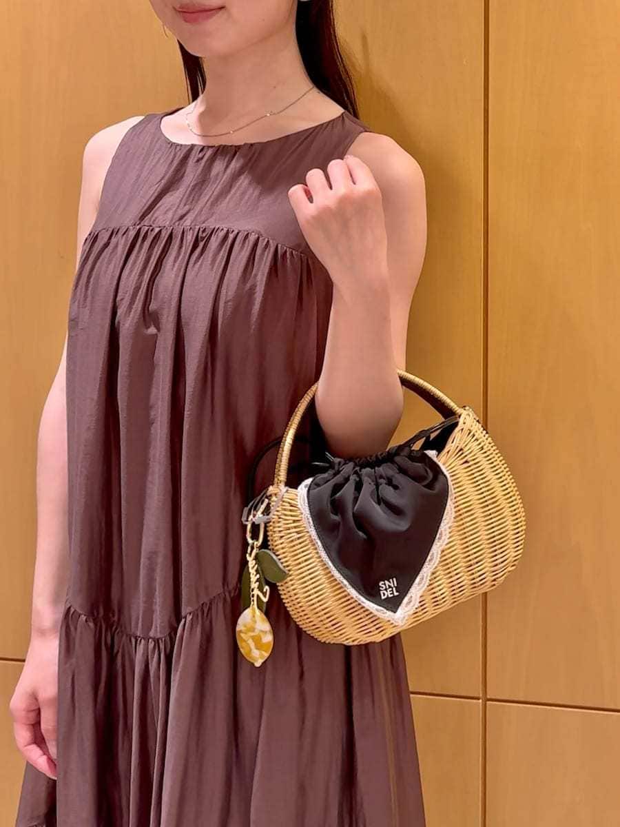ブラック系のかごバッグ、ブラウン系のワンピースを着用したレディースの夏コーディネートの8枚目の写真
