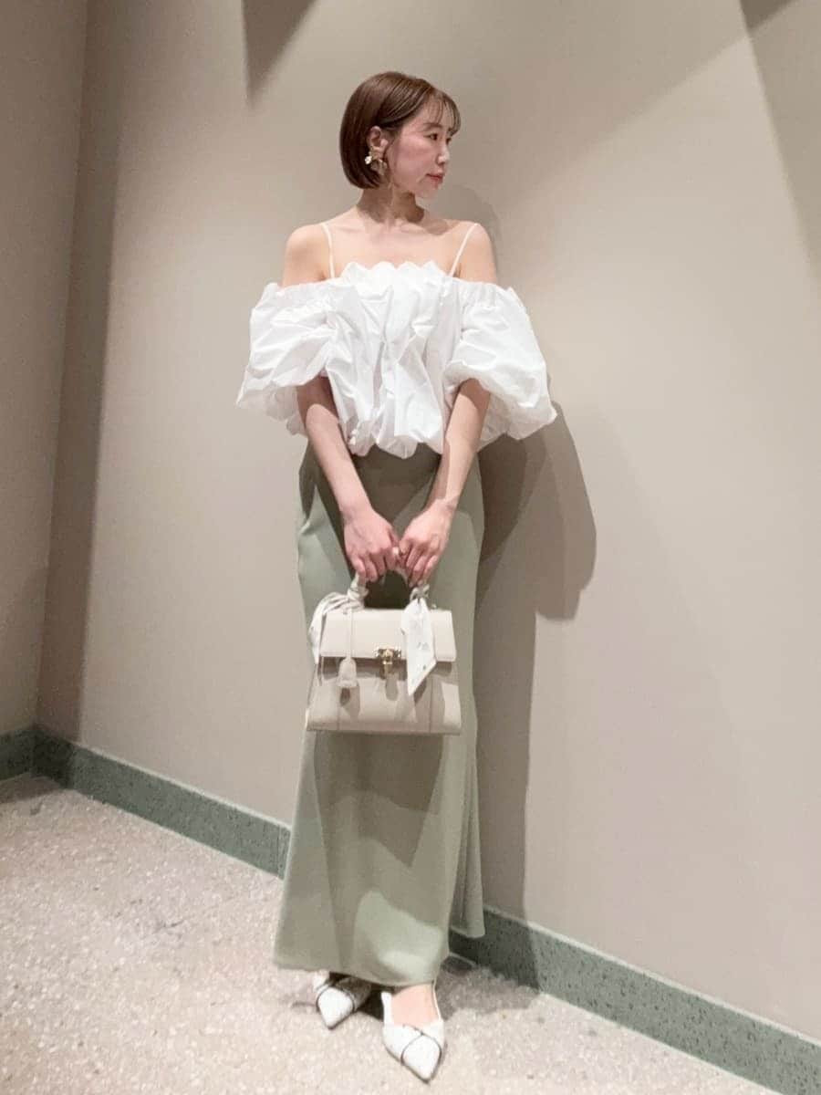 グリーン系のスカート、ホワイト系のシャツ/ブラウス、ホワイト系のハンドバッグを着用したレディースの春コーディネートの5枚目の写真