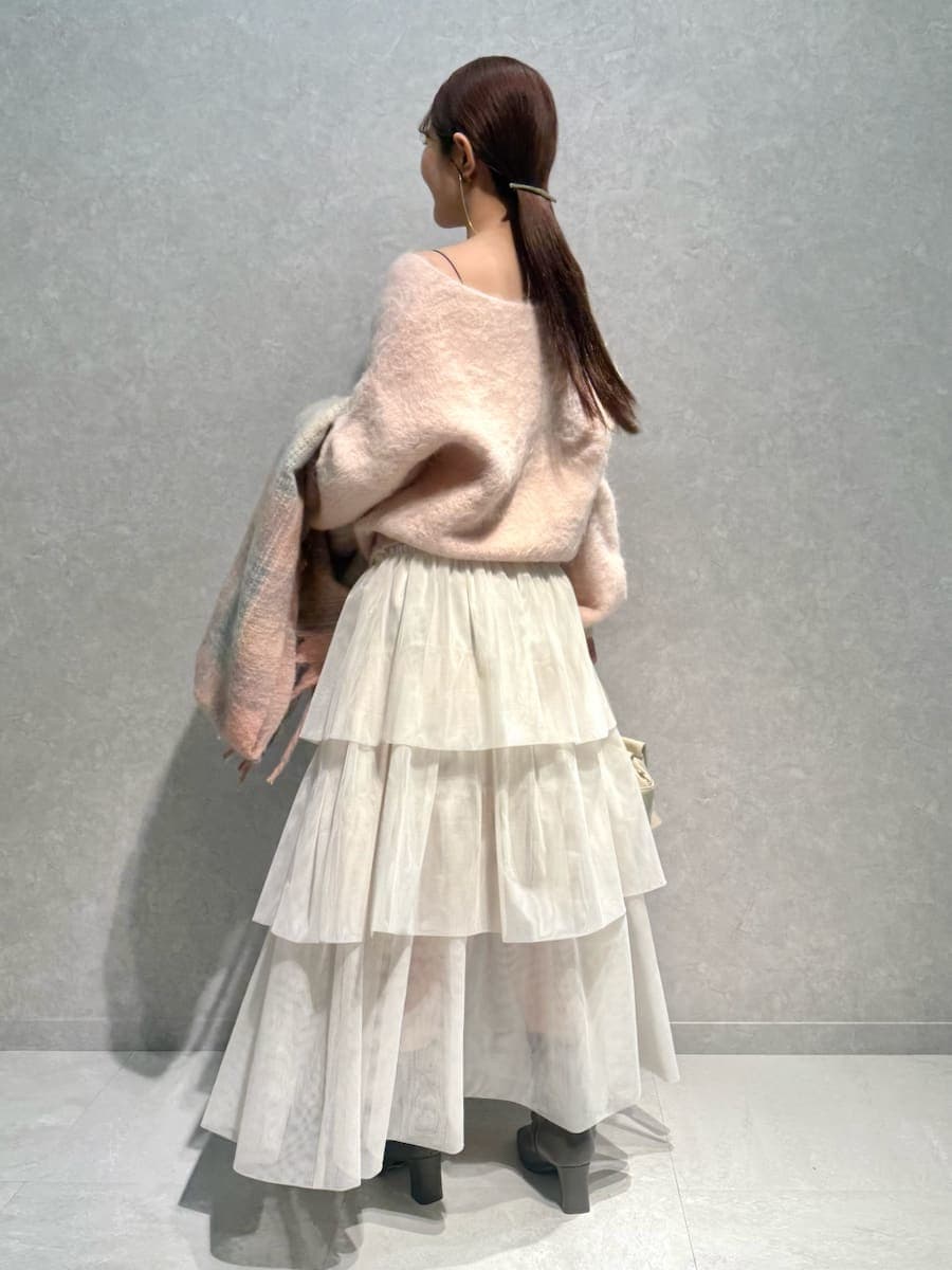 ピンク系のニット/セーター、ホワイト系のチェスターコート、ホワイト系のスカートを着用したレディースの冬コーディネートの5枚目の写真