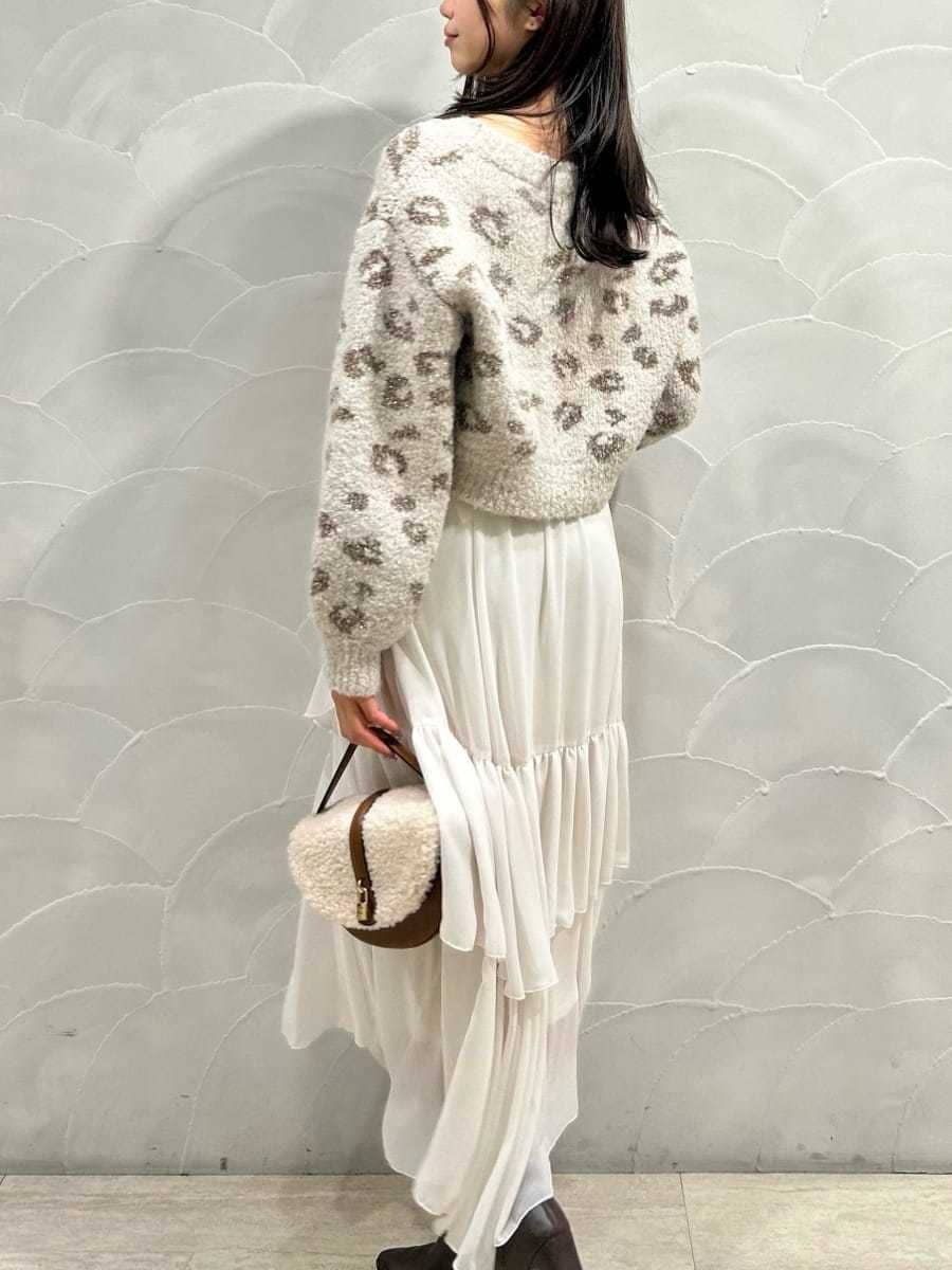 レッド系のブーツ、イエロー系のハンドバッグ、ホワイト系のスカートを着用したレディースの秋コーディネートの5枚目の写真