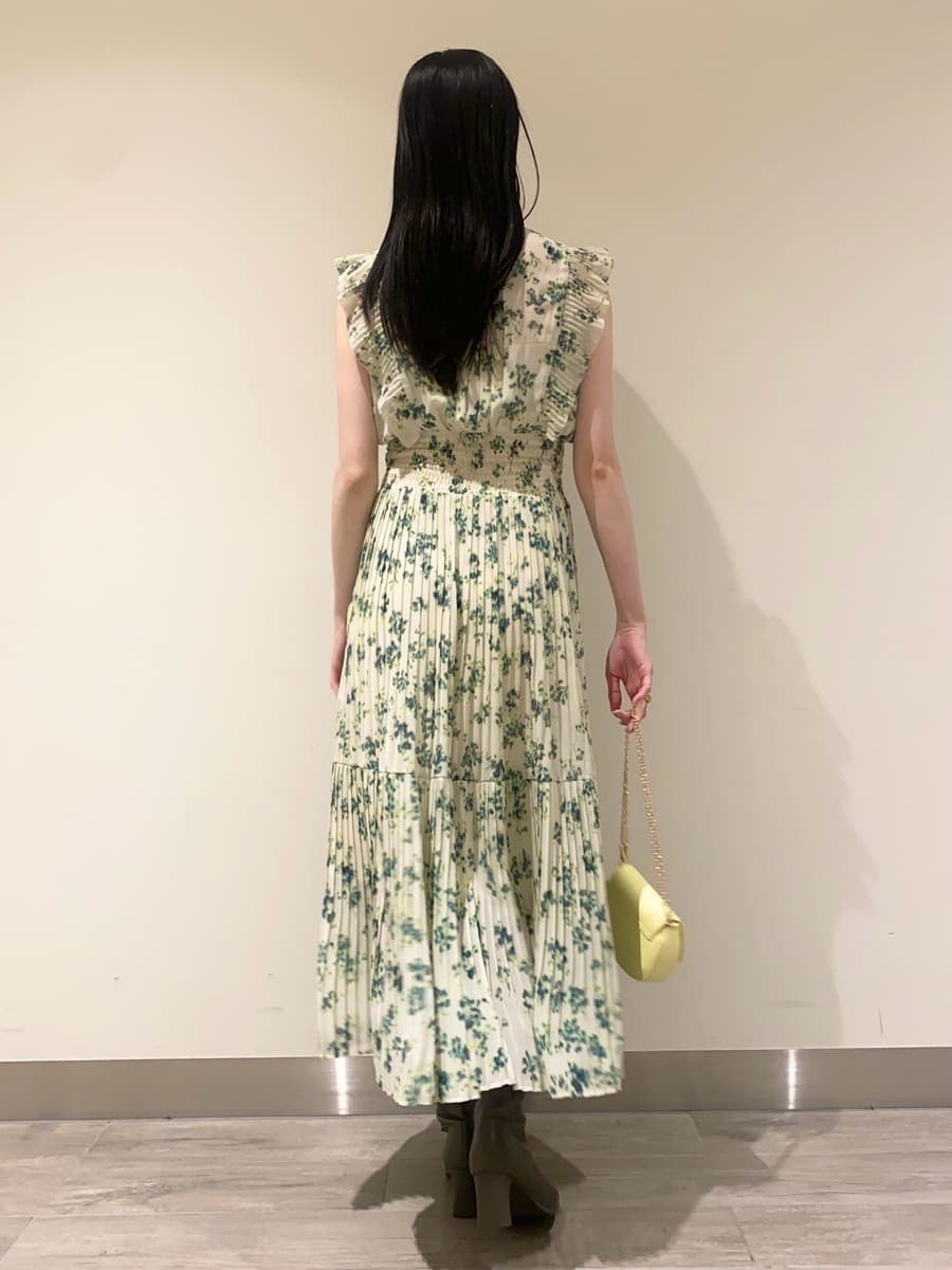 グリーン系のワンピース、ホワイト系のテーラードジャケット、イエロー系のショルダーバッグを着用したレディースの冬コーディネートの6枚目の写真