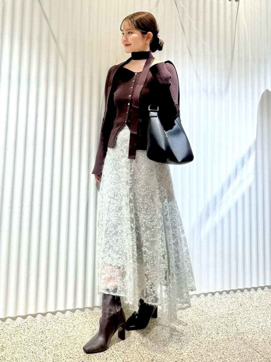 ブラウン系のニット/セーター、グリーン系のスカート、レッド系のブーツを着用したレディースの秋コーディネートの3枚目の写真