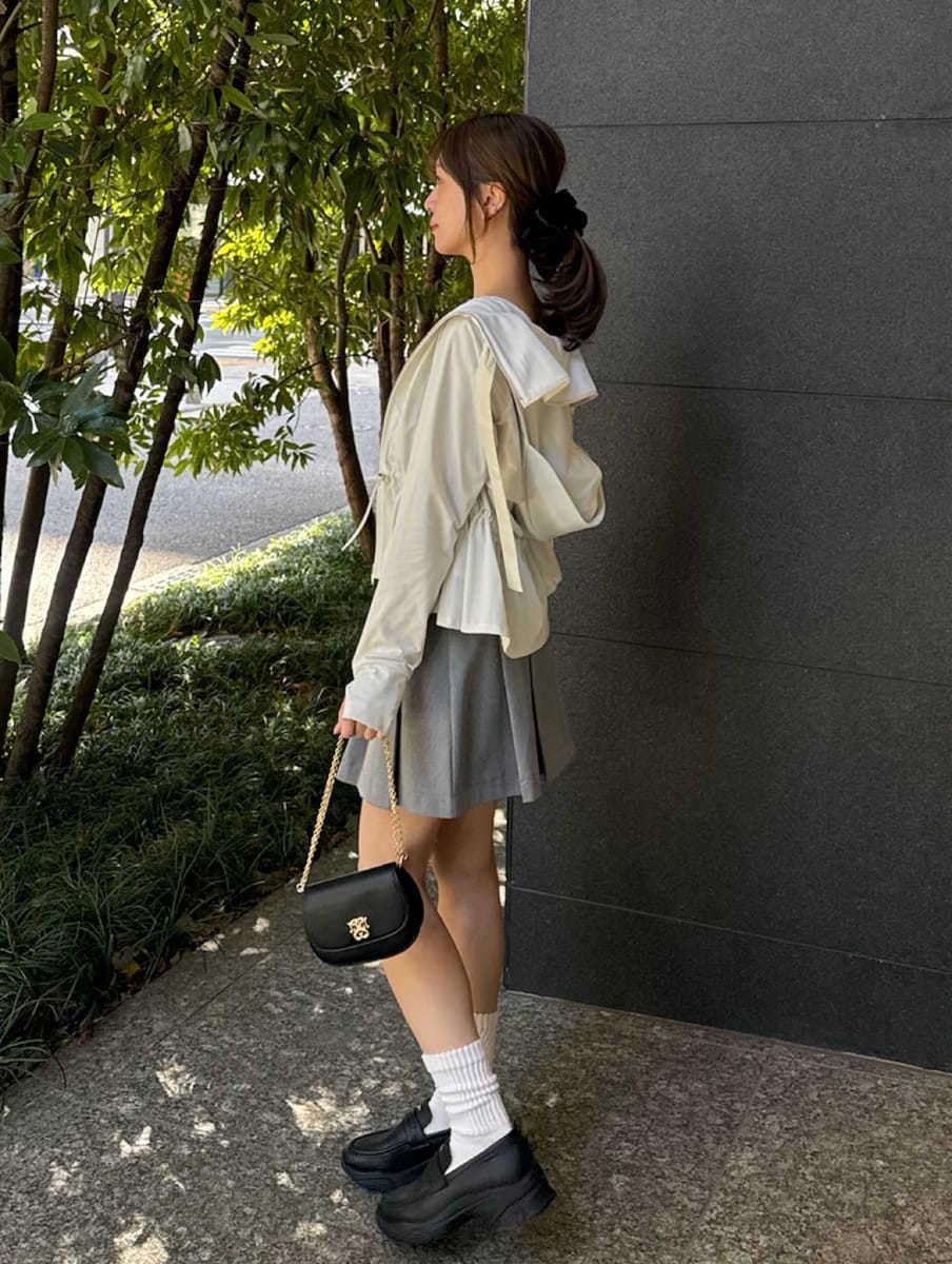 グレー系のスカート、ブラック系のキャミソール、ブラック系のショルダーバッグを着用したレディースの春コーディネートの2枚目の写真