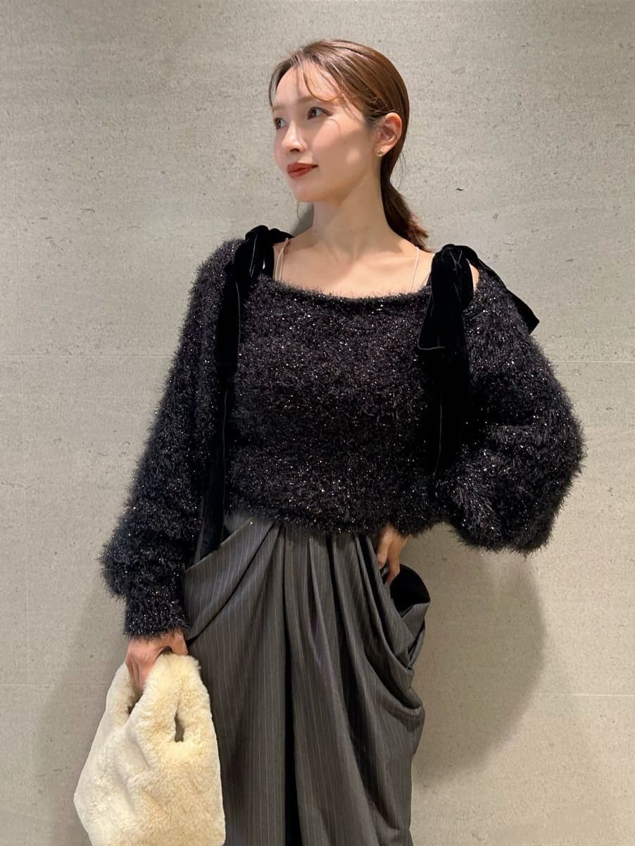 グレー系のその他パンツ、ブラック系のニット/セーター、イエロー系のハンドバッグを着用したレディースの冬コーディネートの2枚目の写真