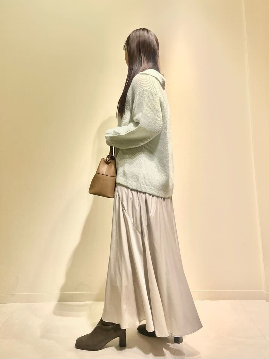 グリーン系のワンピース、イエロー系のハンドバッグを着用したレディースの冬コーディネートの3枚目の写真