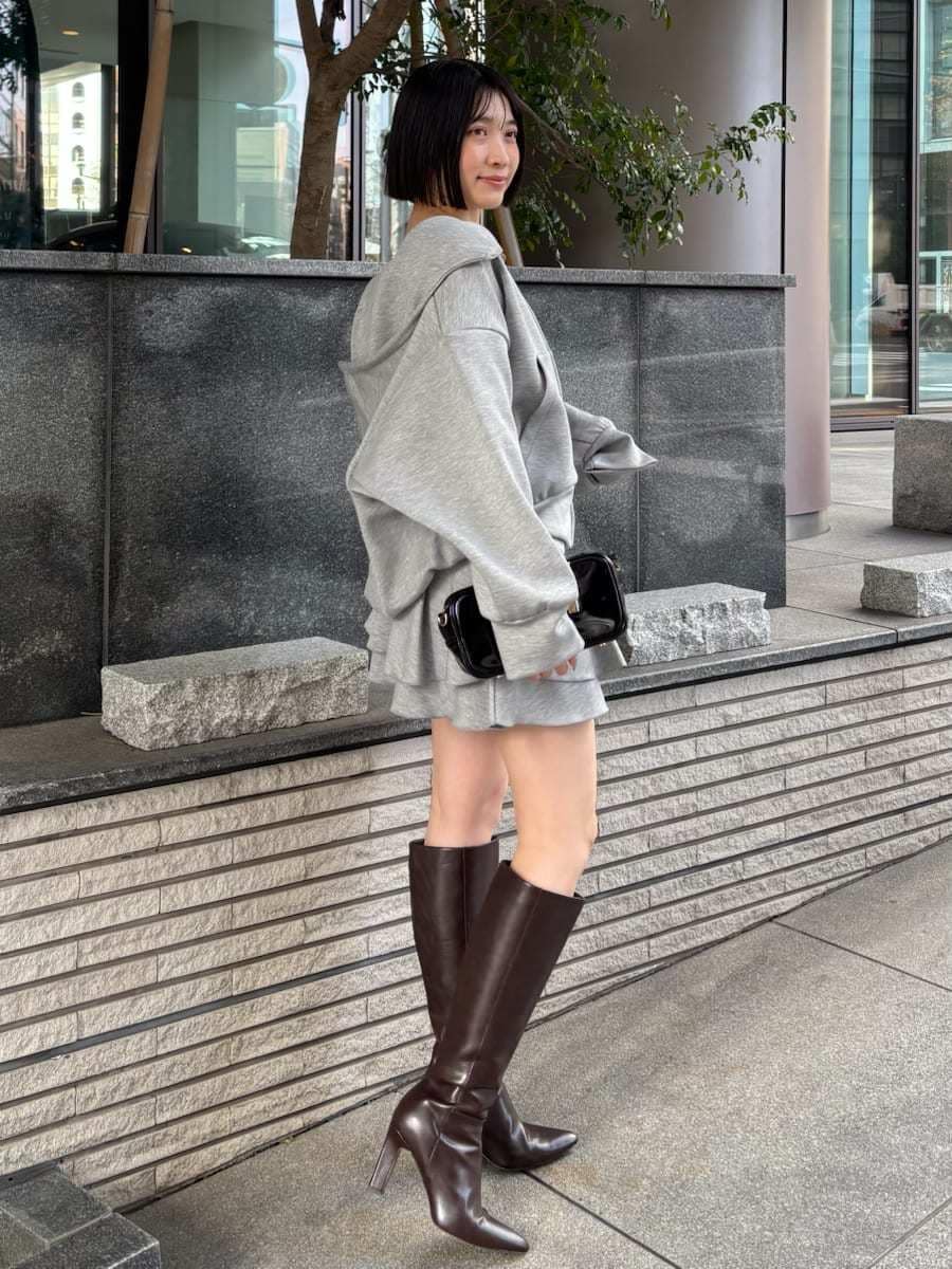 ブラウン系のブーツ、グレー系のパーカー、ブラック系のボストンバッグを着用したレディースの冬コーディネートの4枚目の写真