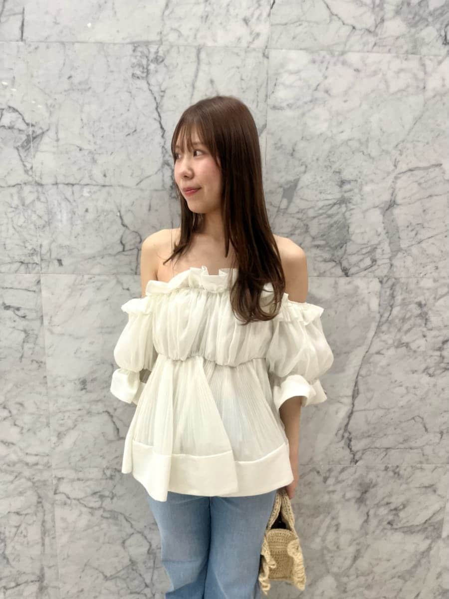 ブルー系のデニムパンツ、ホワイト系のその他トップス、ベージュ系のショルダーバッグを着用したレディースの春コーディネートの5枚目の写真