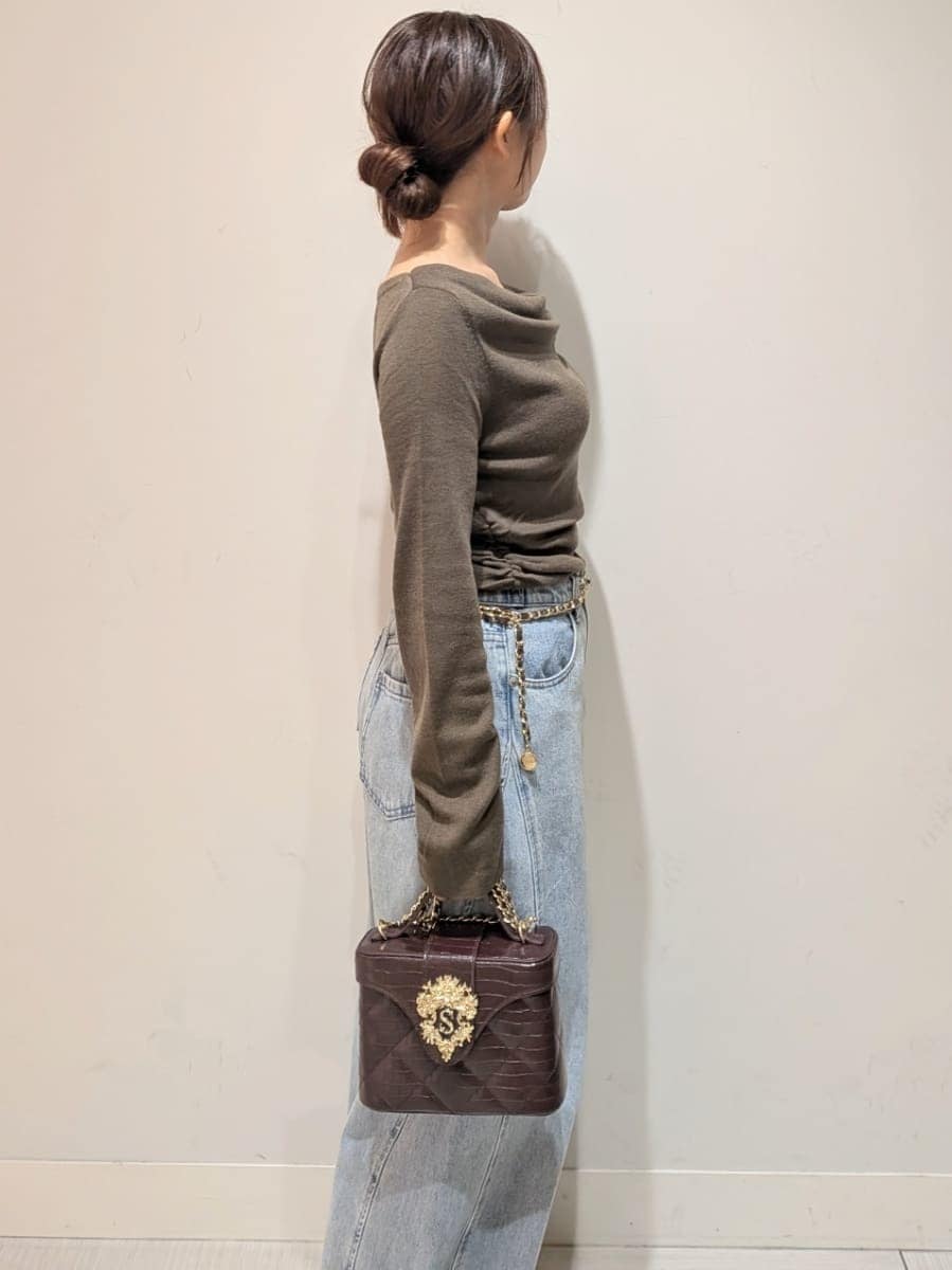 ブルー系のデニムパンツ、ブラウン系のニット/セーター、ブラウン系のパンプスを着用したレディースの秋コーディネートの4枚目の写真