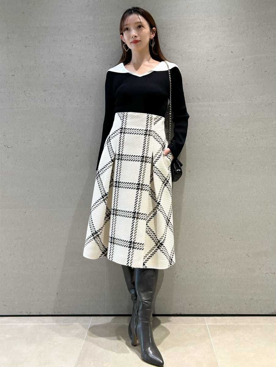 ブラック系のニット/セーター、ホワイト系のスカート、グレー系のブーツを着用したレディースの秋コーディネートの2枚目の写真