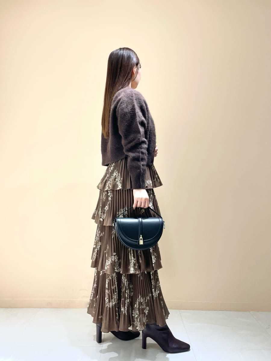 ブラウン系のカーディガン/ボレロ、ブラウン系のワンピース、ブラック系のハンドバッグを着用したレディースの秋コーディネートの3枚目の写真