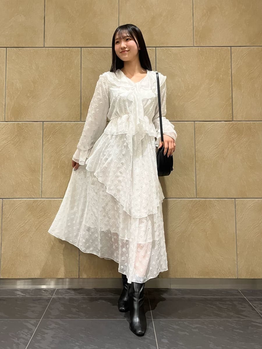 ブラック系のブーツ、ブラック系のハンドバッグ、シルバー系のスカートを着用したレディースの冬コーディネートの2枚目の写真