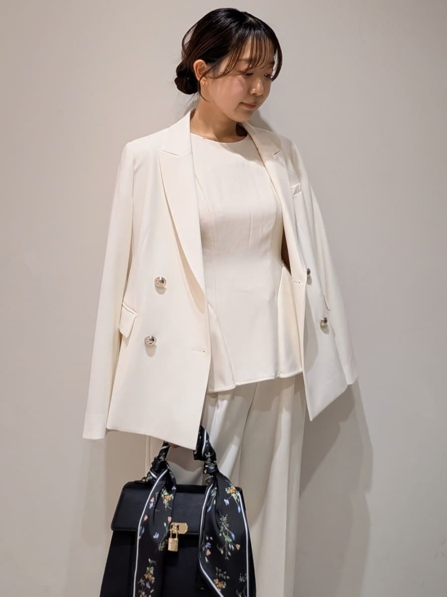 ホワイト系のテーラードジャケット、ホワイト系のワンピース、ブラック系のパンプスを着用したレディースの春コーディネートの3枚目の写真