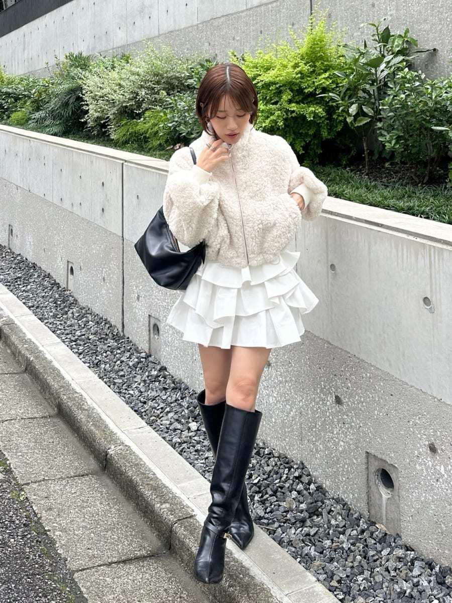 ホワイト系のその他パンツ、ブラック系のブーツ、ブラック系のショルダーバッグを着用したレディースの秋コーディネートの6枚目の写真