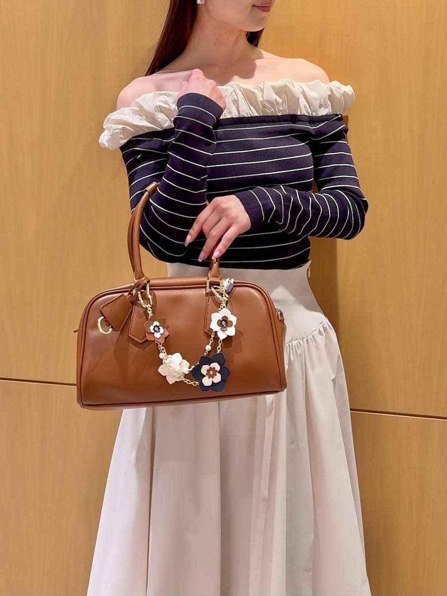 ブラック系のブーツ、ホワイト系のスカート、その他のニット/セーターを着用したレディースの冬コーディネートの8枚目の写真