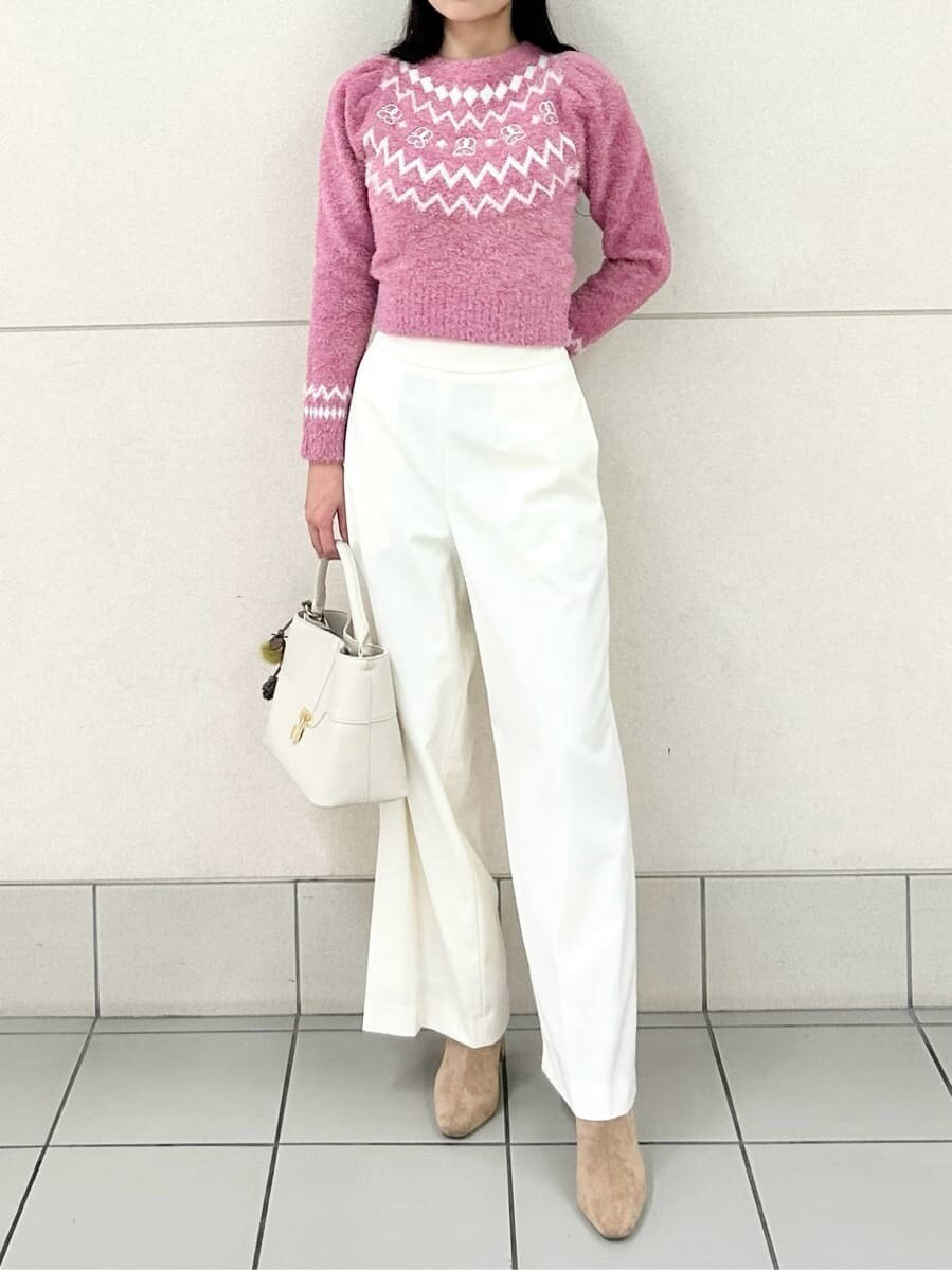 ベージュ系のブーツ、ホワイト系のスラックス、ピンク系のニット/セーターを着用したレディースの冬コーディネートの2枚目の写真