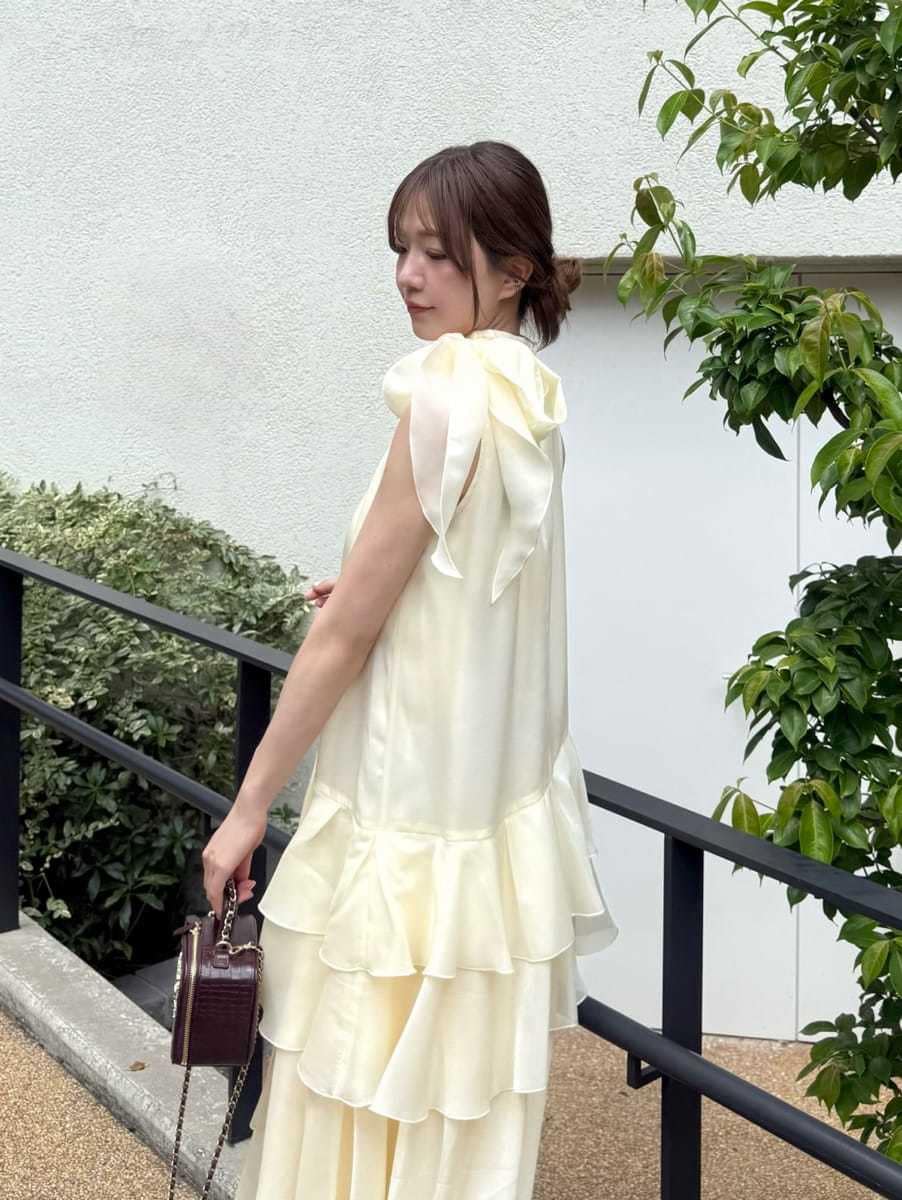 イエロー系のドレス、ブラウン系のサンダル、レッド系のショルダーバッグを着用したレディースの夏コーディネートの4枚目の写真