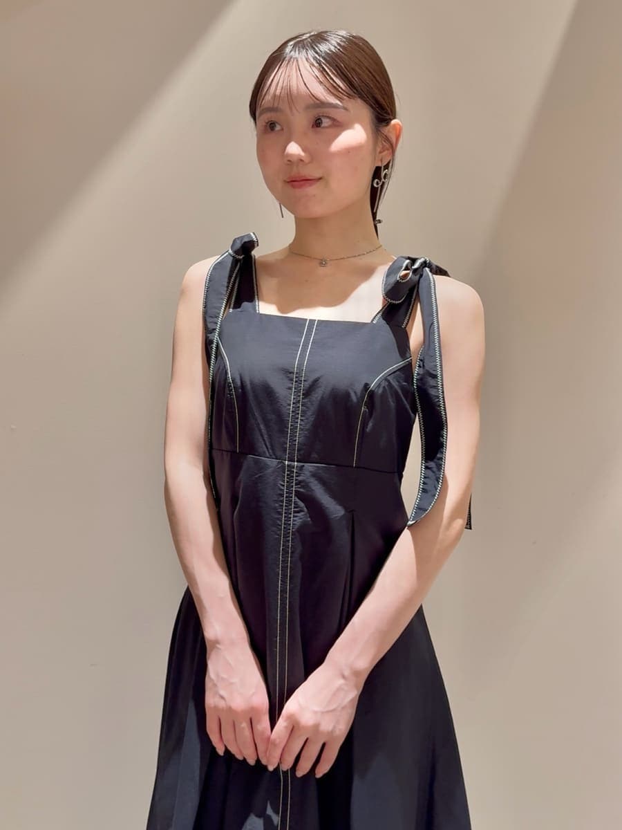 ブラック系のワンピース、ベージュ系のショルダーバッグ、シルバー系のネックレスを着用したレディースの夏コーディネートの4枚目の写真