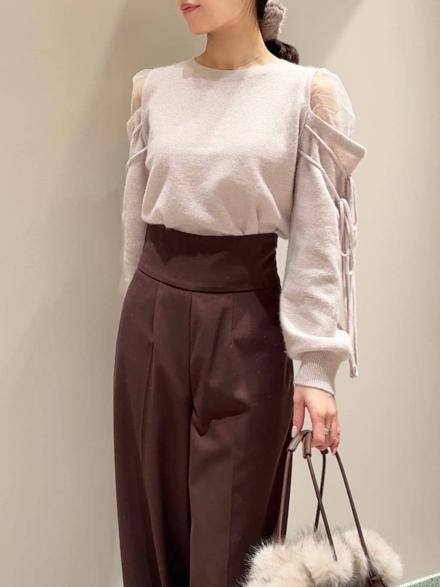 ブラウン系のスラックス、ピンク系のニット/セーター、ブラウン系のハンドバッグを着用したレディースの冬コーディネートの4枚目の写真