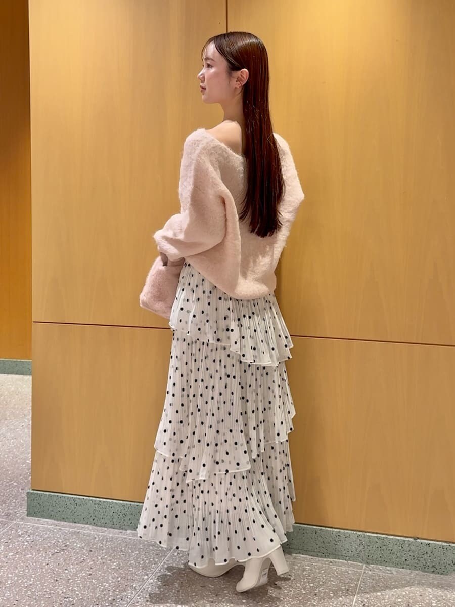 ピンク系のニット/セーター、その他のスカート、ピンク系のハンドバッグを着用したレディースの秋コーディネートの2枚目の写真