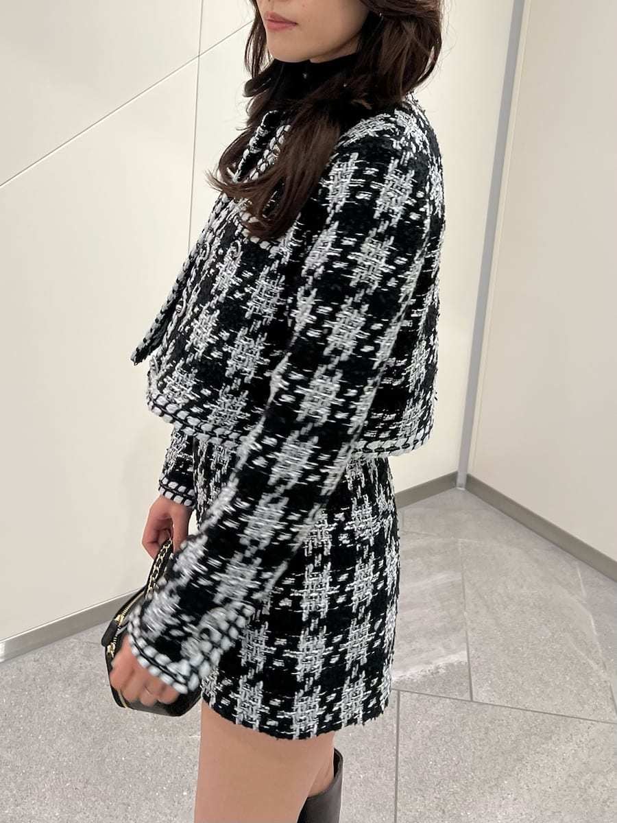 ブラック系のノーカラージャケット、ブラック系のニット/セーター、ブラウン系のブーツを着用したレディースの秋コーディネートの5枚目の写真