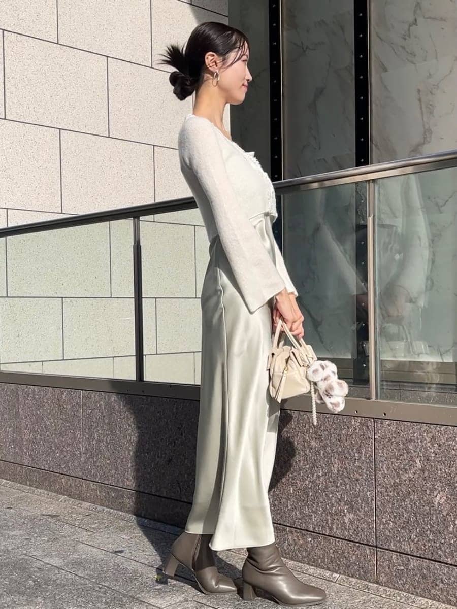 ホワイト系のチェスターコート、ホワイト系のワンピース、ホワイト系のボストンバッグを着用したレディースの秋コーディネートの8枚目の写真