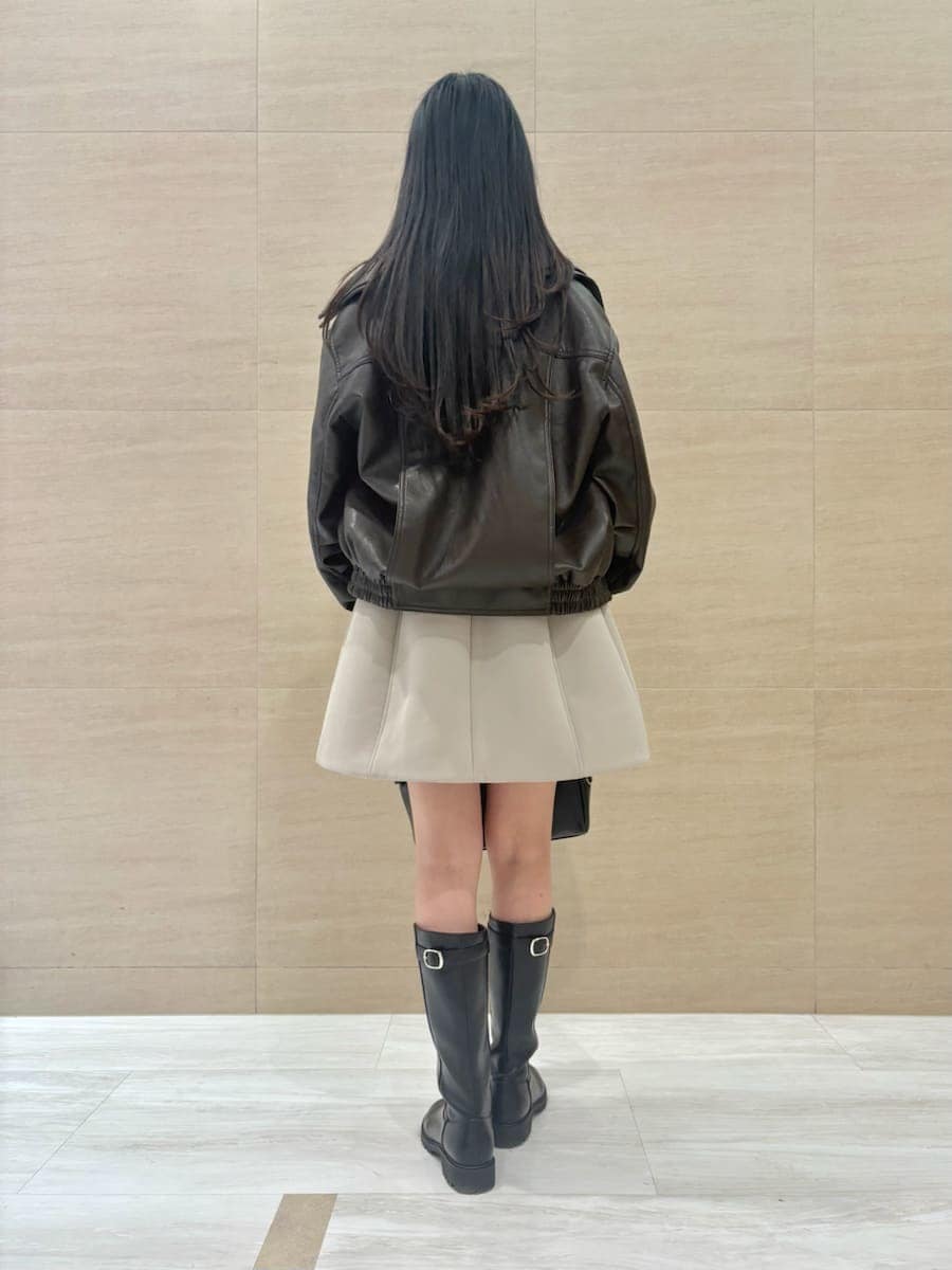 ブラウン系のブルゾン、グリーン系のワンピース、イエロー系のボストンバッグを着用したレディースの冬コーディネートの3枚目の写真