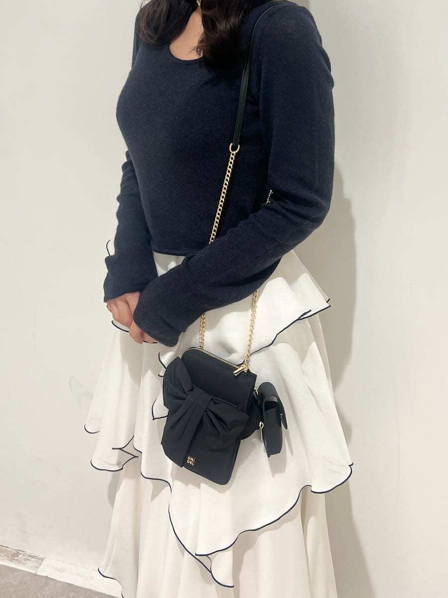 ブルー系のワンピース、ブラック系のパンプス、ブラック系のショルダーバッグを着用したレディースの冬コーディネートの5枚目の写真