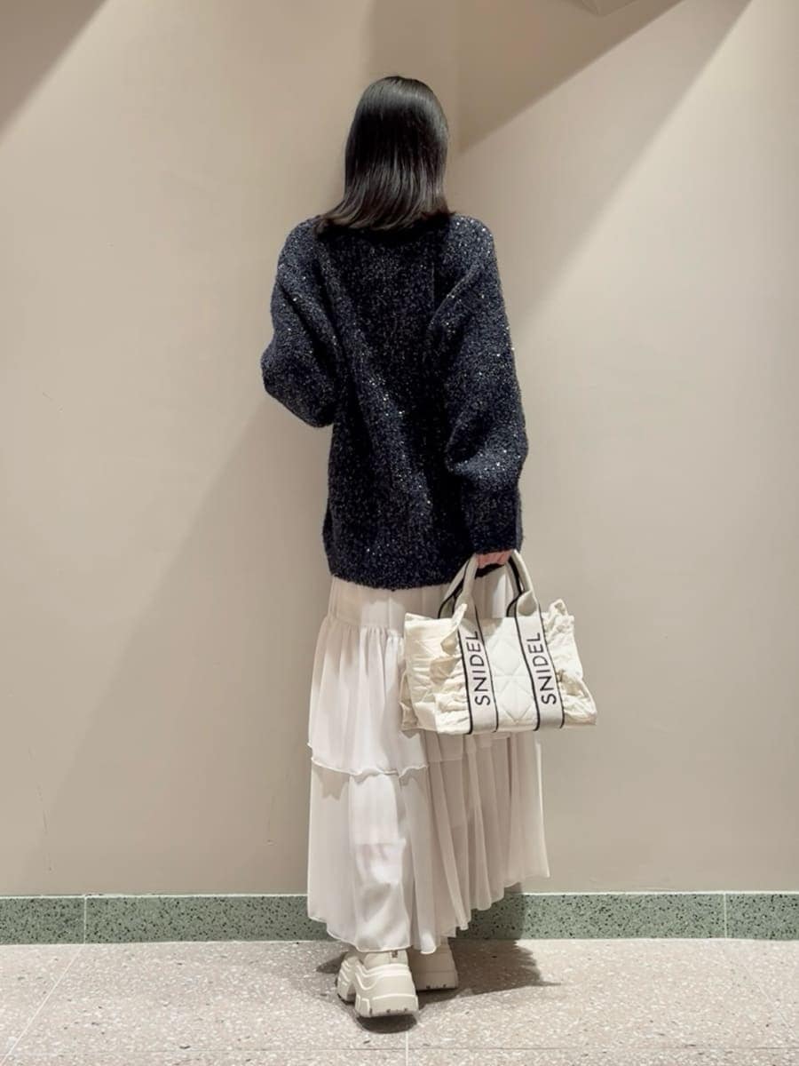 ブルー系のカーディガン/ボレロ、ホワイト系のスカート、ホワイト系のハンドバッグを着用したレディースの秋コーディネートの3枚目の写真