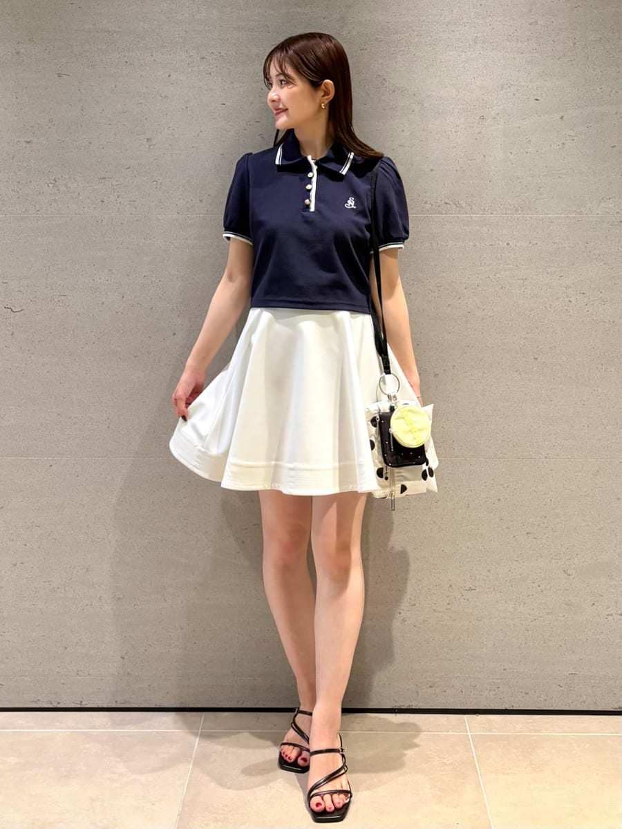 ホワイト系のその他パンツ、ブルー系のポロシャツ、ブラック系のサンダルを着用したレディースの春コーディネートの2枚目の写真