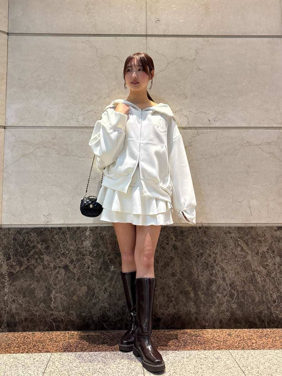 ブラウン系のブーツ、ブラック系のショルダーバッグ、ホワイト系のパーカーを着用したレディースの冬コーディネートの3枚目の写真