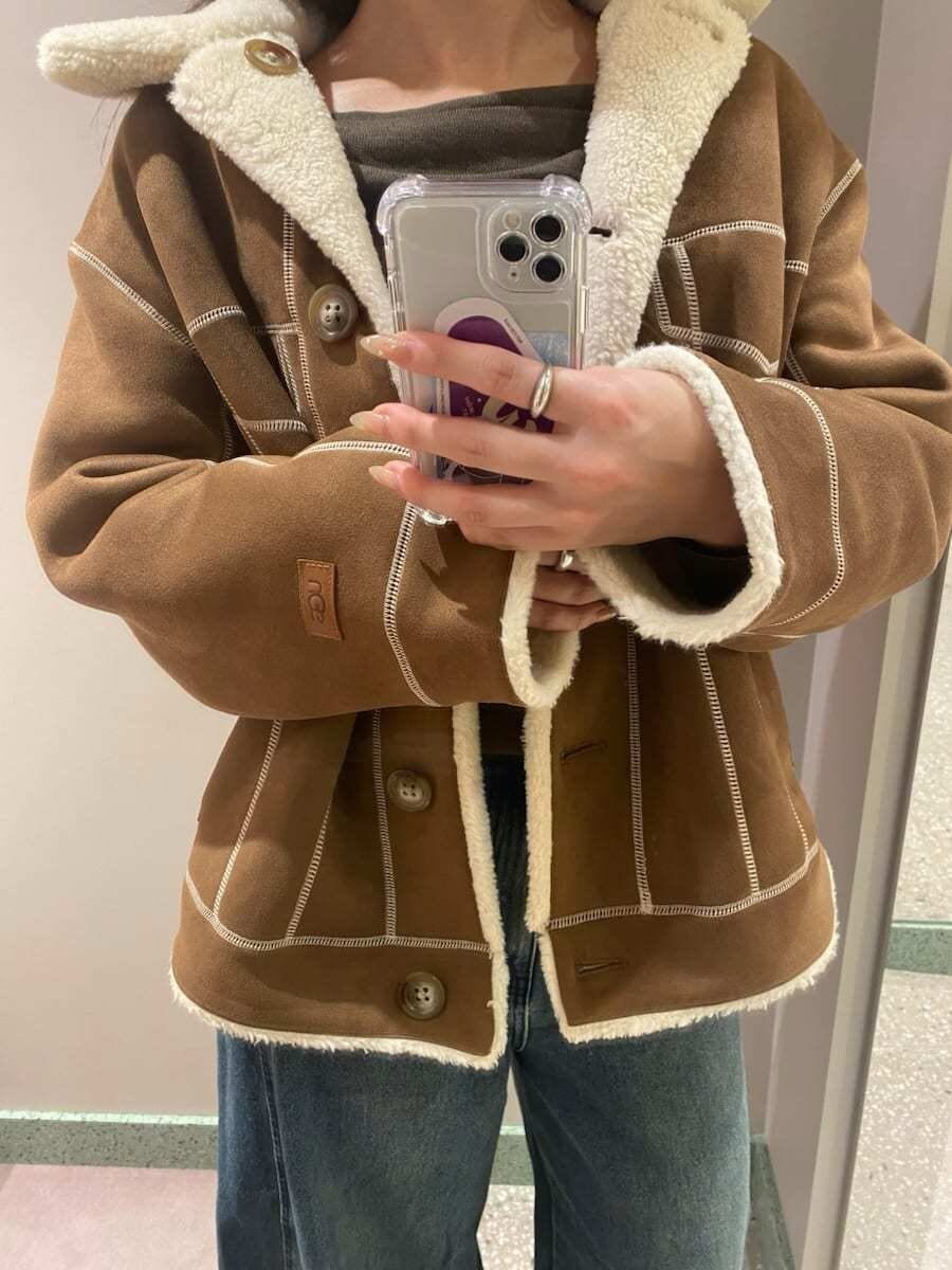 ブルー系のデニムパンツ、ブラウン系のニット/セーター、ブラック系のブーツを着用したレディースの秋コーディネートの7枚目の写真