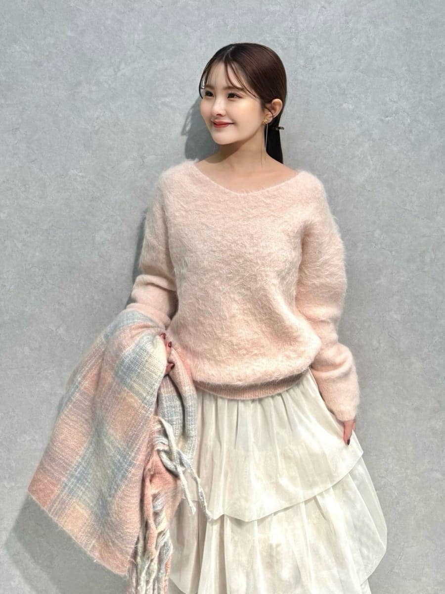 ピンク系のニット/セーター、ホワイト系のチェスターコート、ホワイト系のスカートを着用したレディースの冬コーディネートの7枚目の写真