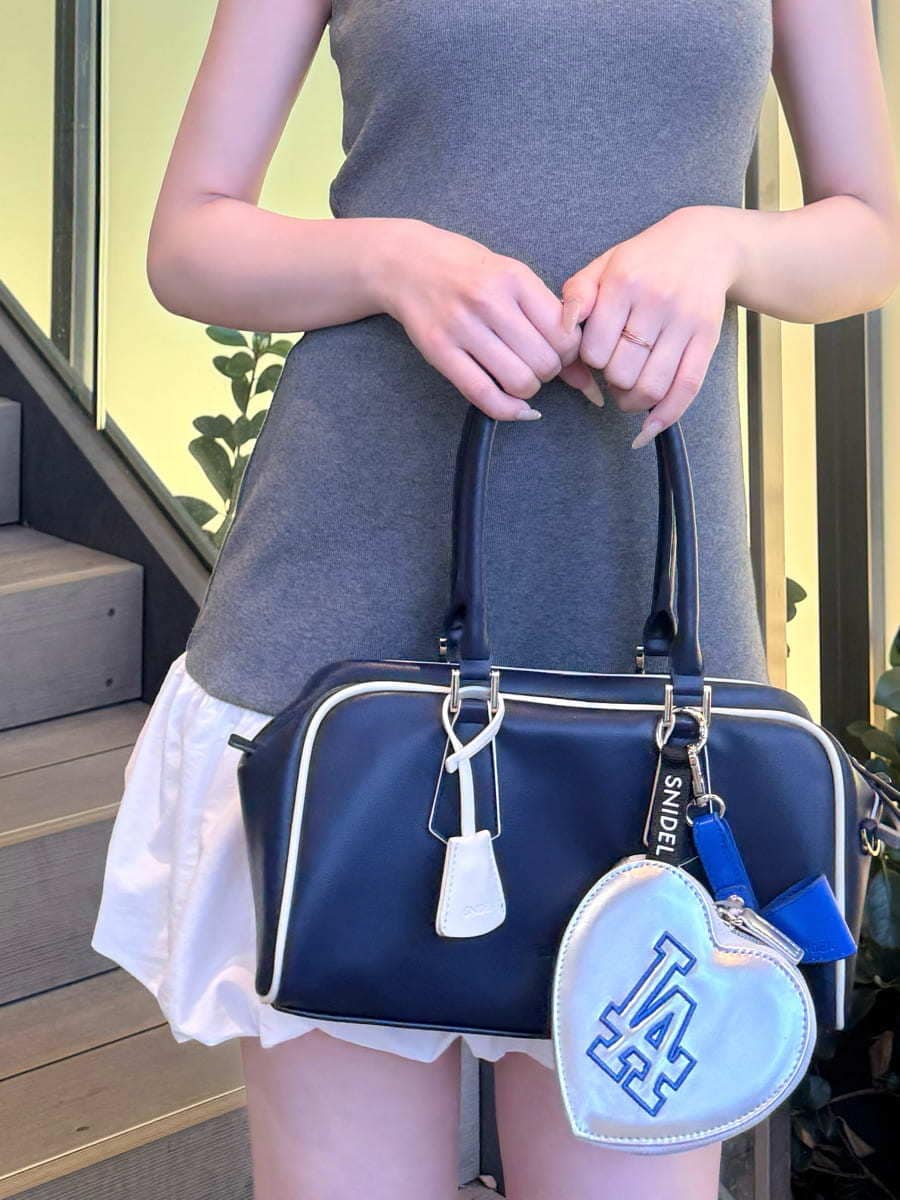 グレー系のワンピース、ブルー系のボストンバッグ、シルバー系のキーケース/キーアクセサリーを着用したレディースの春コーディネートの5枚目の写真