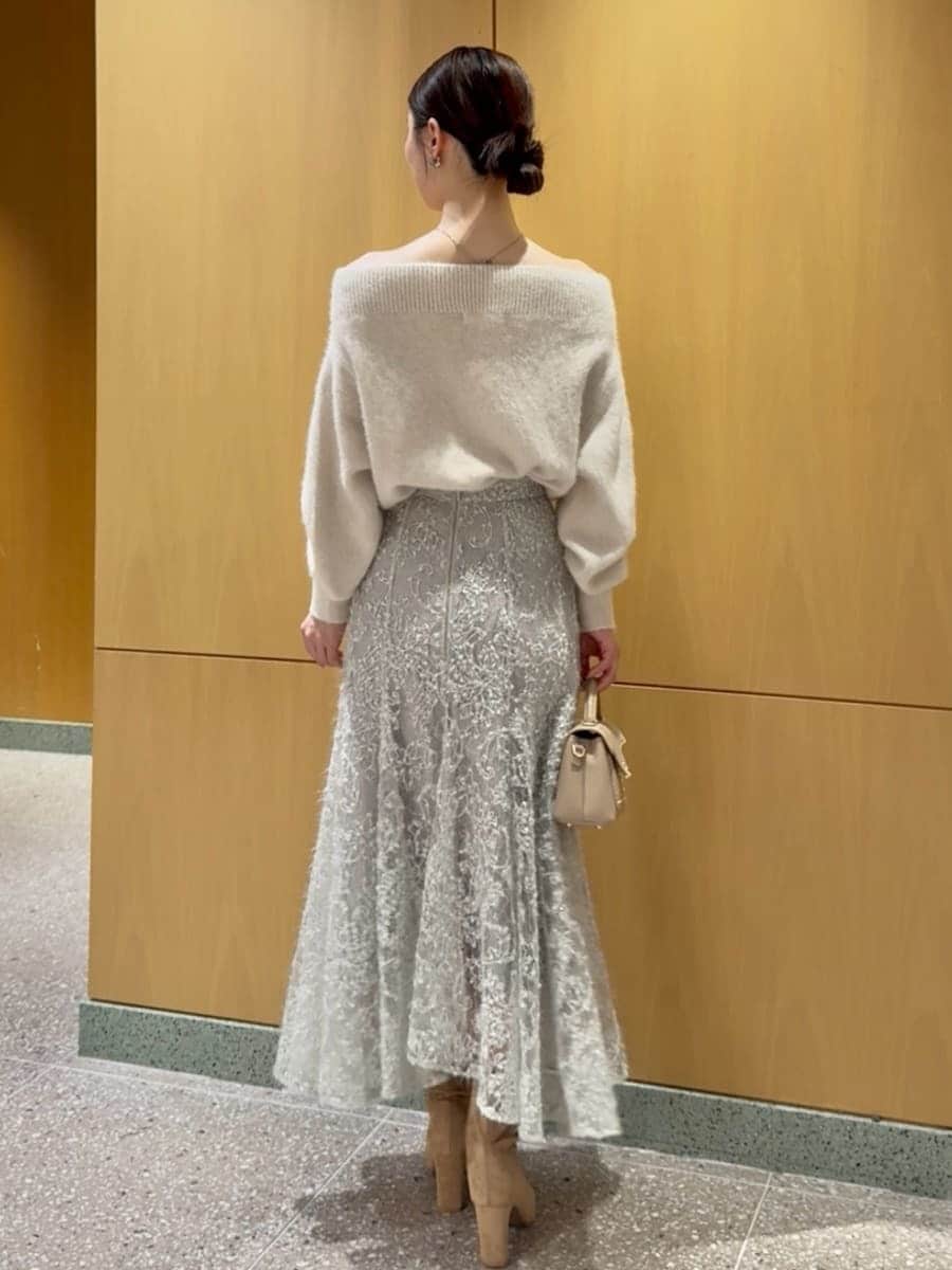 ホワイト系のニット/セーター、グリーン系のスカート、ベージュ系のブーツを着用したレディースの秋コーディネートの3枚目の写真