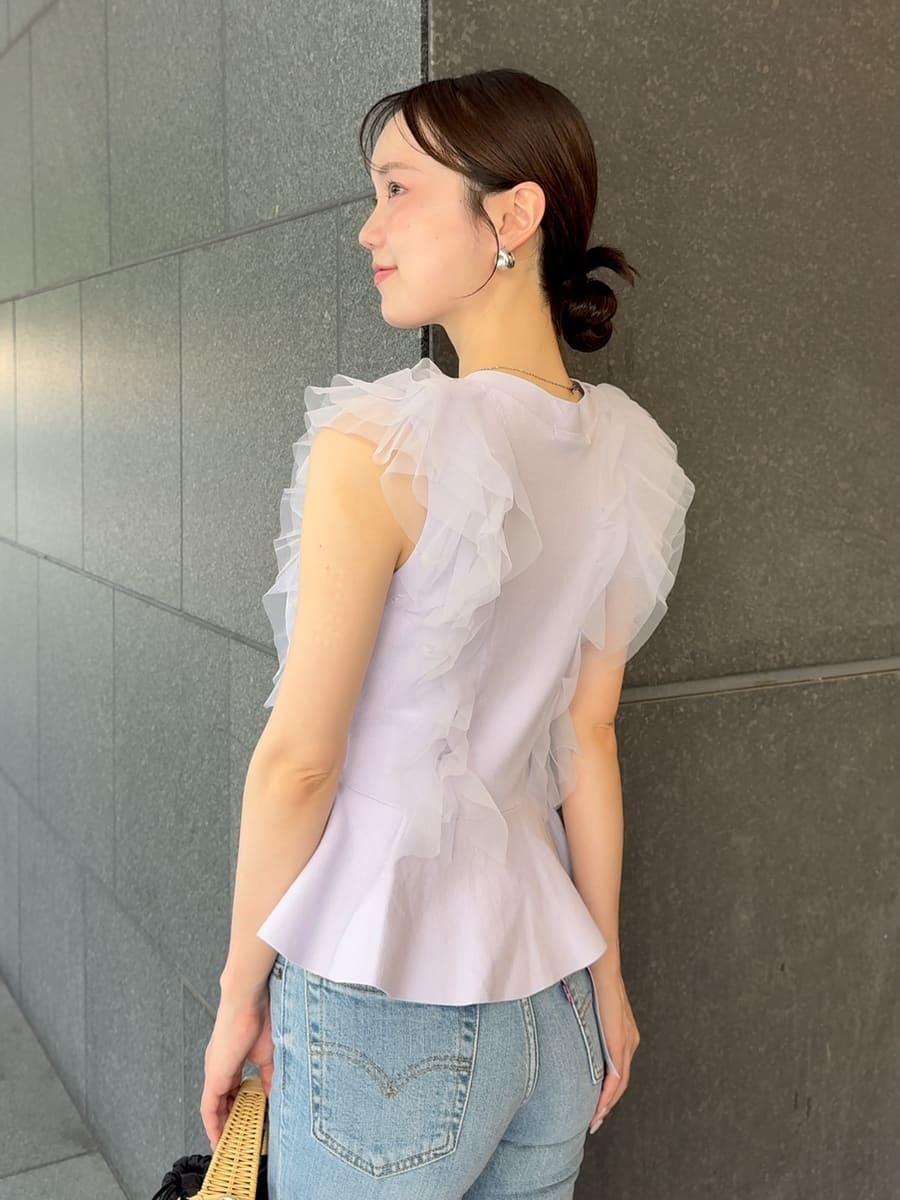 ブルー系のデニムパンツ、ブラック系のかごバッグ、パープル系のニット/セーターを着用したレディースの夏コーディネートの6枚目の写真