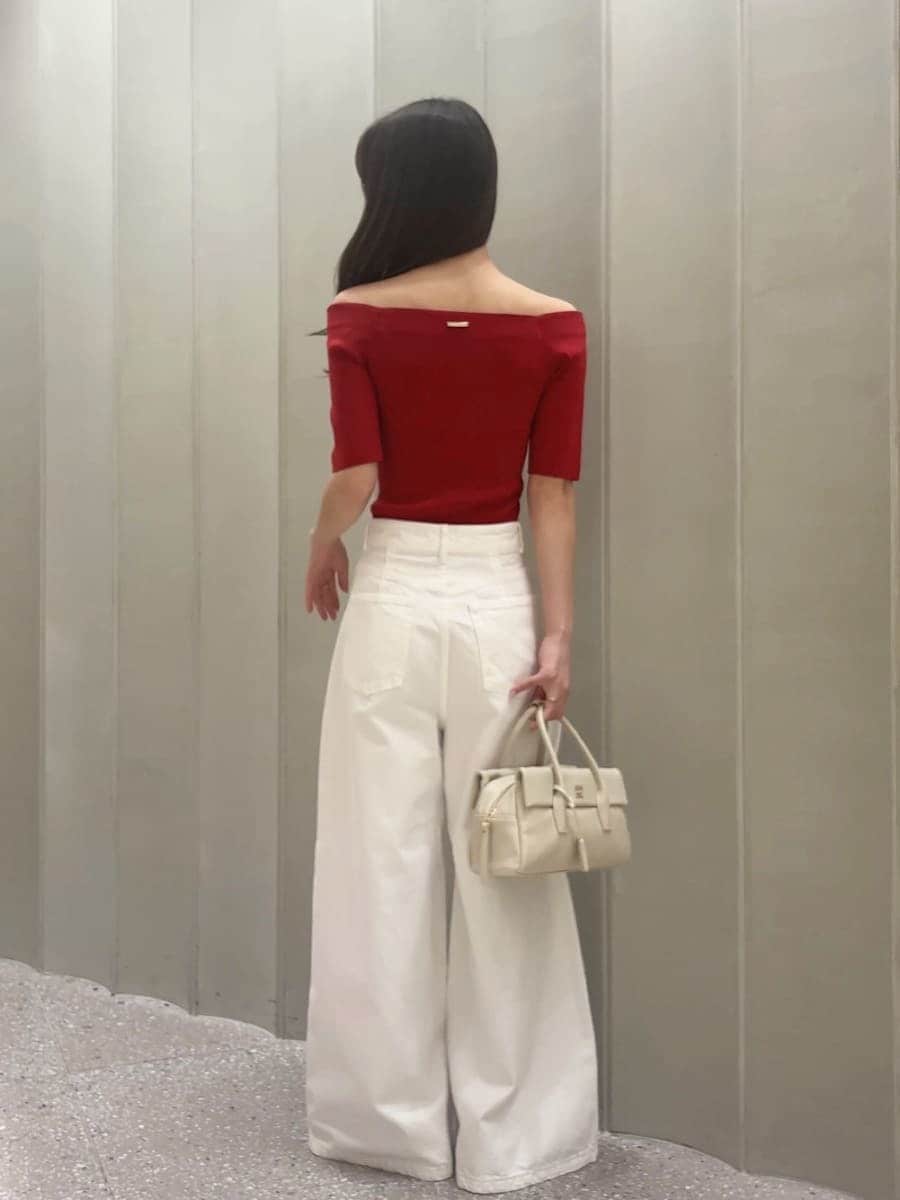 ホワイト系のボストンバッグ、ホワイト系のデニムパンツ、レッド系のニット/セーターを着用したレディースの夏コーディネートの4枚目の写真