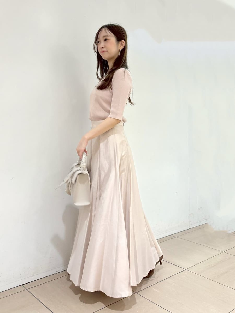 ブラウン系のパンプス、ベージュ系のハンドバッグ、ピンク系のニット/セーターを着用したレディースの春コーディネートの2枚目の写真