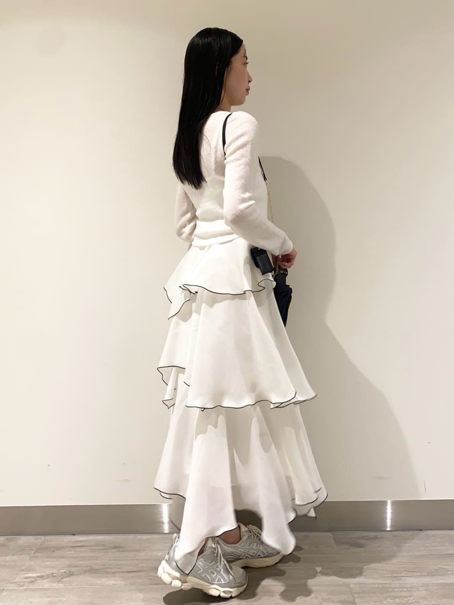 ホワイト系のワンピース、ブラック系のショルダーバッグ、シルバー系のスニーカーを着用したレディースの冬コーディネートの2枚目の写真