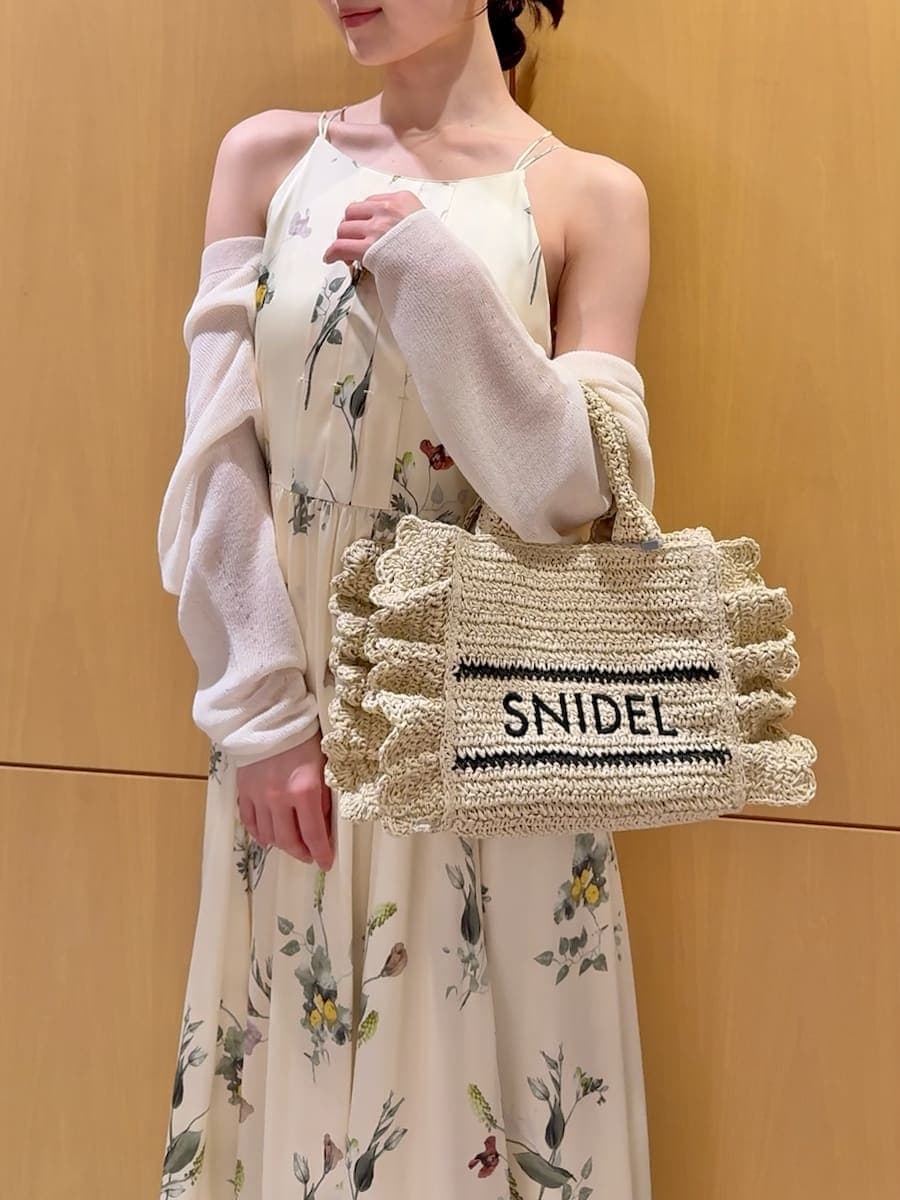 イエロー系のワンピース、ホワイト系のカーディガン/ボレロ、ベージュ系のショルダーバッグを着用したレディースの春コーディネートの7枚目の写真