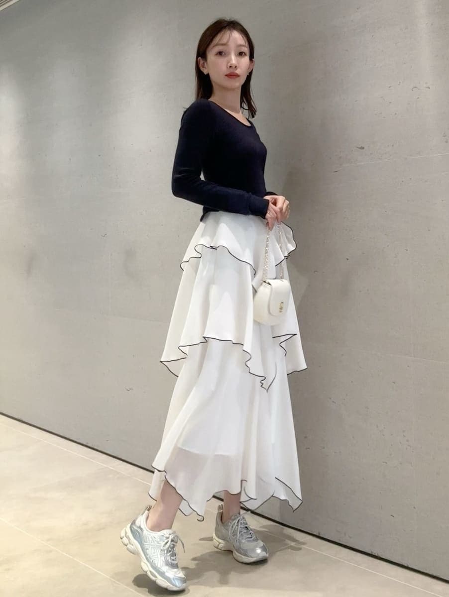 ブルー系のワンピース、ホワイト系のショルダーバッグ、シルバー系のスニーカーを着用したレディースの冬コーディネートの4枚目の写真