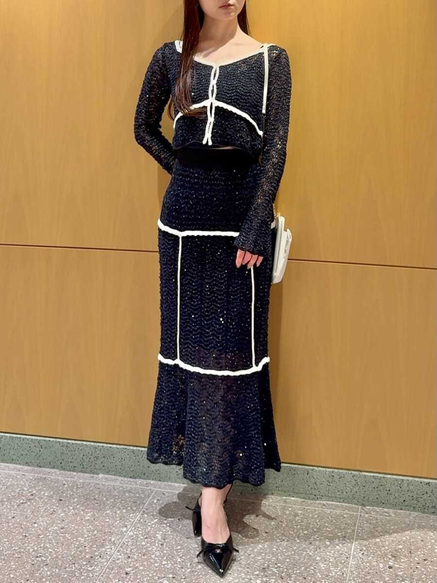 ブルー系のスカート、ブルー系のニット/セーター、ホワイト系のショルダーバッグを着用したレディースの春コーディネートの7枚目の写真