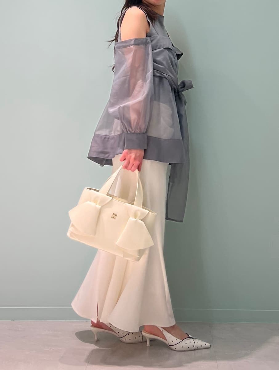 ホワイト系のスカート、グレー系のニット/セーター、その他のパンプスを着用したレディースの春コーディネートの4枚目の写真