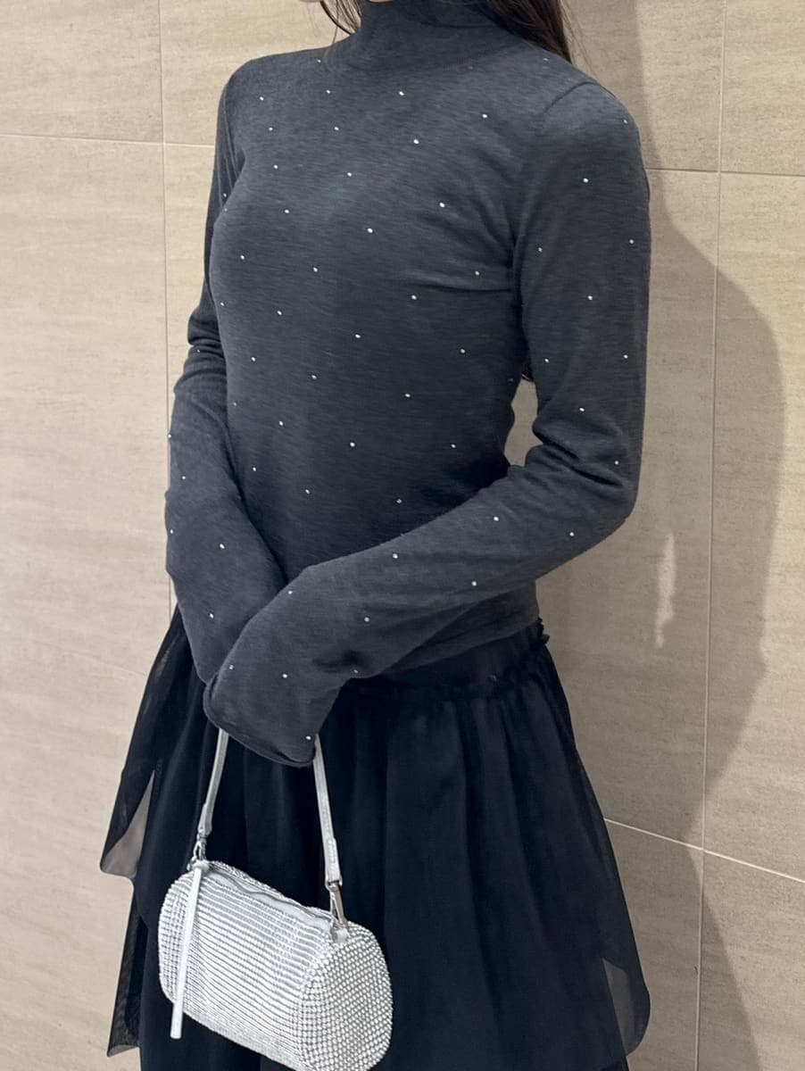 ブラック系のブーツ、ブラック系のスカート、グレー系のニット/セーターを着用したレディースの冬コーディネートの6枚目の写真