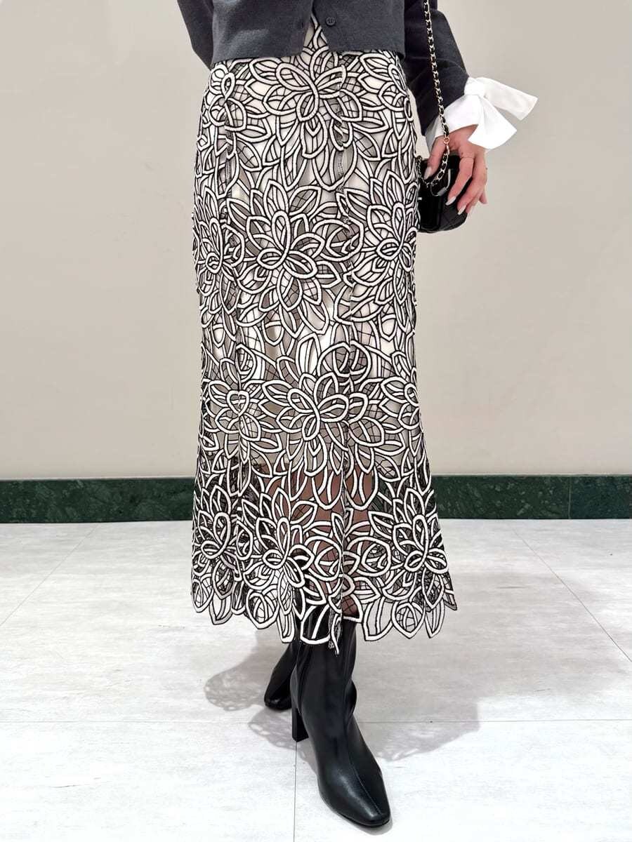 グレー系のニット/セーター、その他のスカート、ブラック系のブーツを着用したレディースの秋コーディネートの6枚目の写真