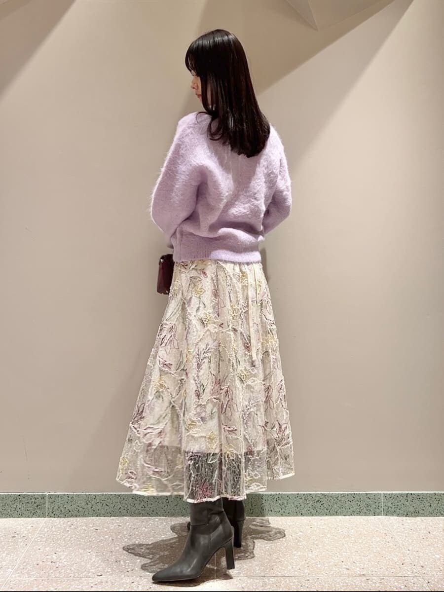 グレー系のブーツ、ブラウン系のショルダーバッグ、パープル系のニット/セーターを着用したレディースの秋コーディネートの2枚目の写真