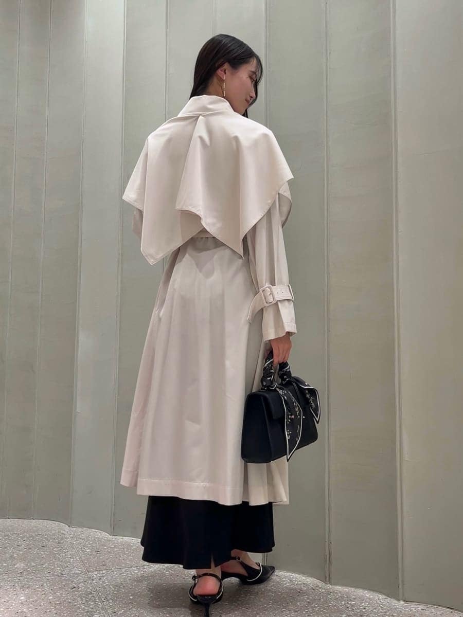 ホワイト系のトレンチコート、ブラック系のスカート、ブラック系のパンプスを着用したレディースの冬コーディネートの2枚目の写真